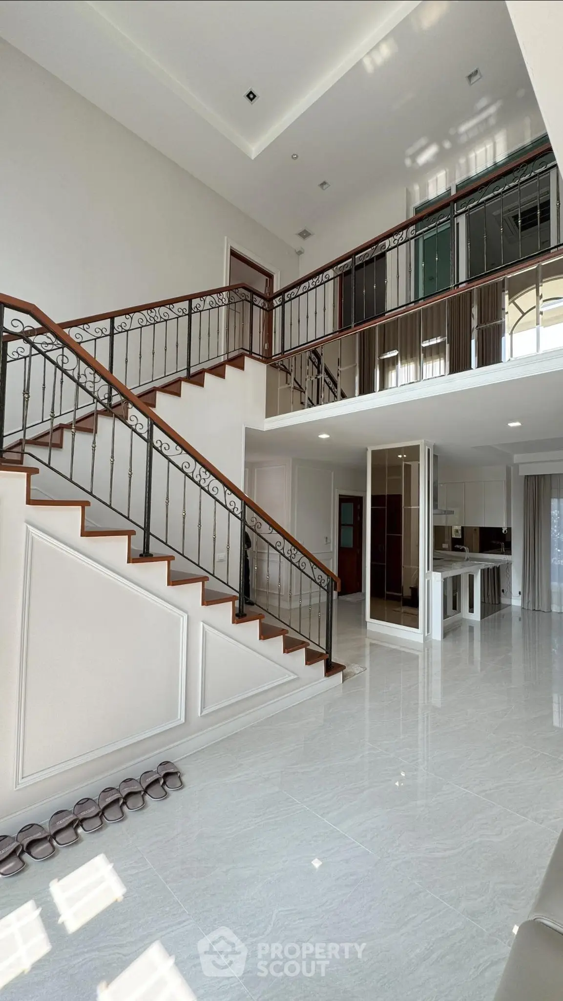 Luxurious open-concept living space with elegant staircase and modern kitchen