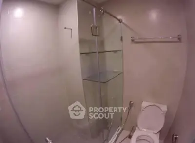 Modern bathroom with glass shower enclosure and sleek fixtures.