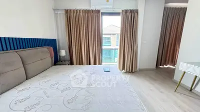 Spacious bedroom with modern decor and large window view