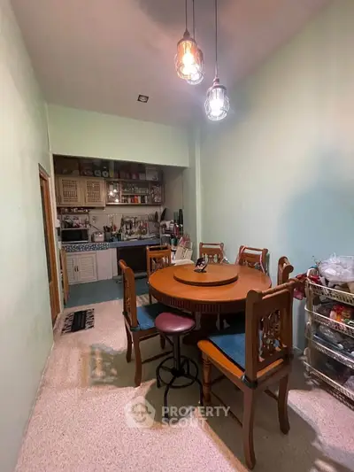 Charming dining area with wooden furniture and cozy lighting in a compact kitchen space.