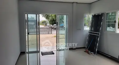 Spacious living room with sliding glass doors and outdoor view, perfect for natural light.