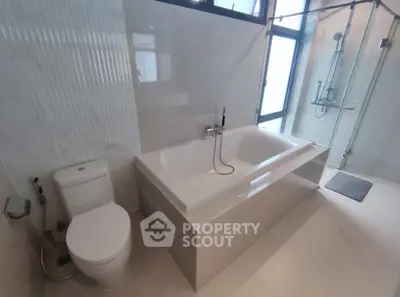 Modern bathroom with bathtub and glass shower enclosure