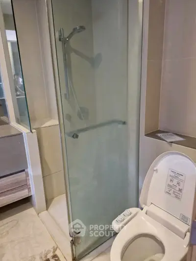 Modern bathroom with glass shower and bidet toilet in sleek design.