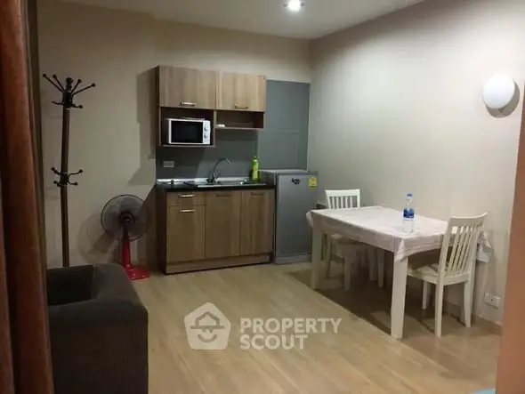 Cozy studio apartment with compact kitchen and dining area, ideal for urban living.