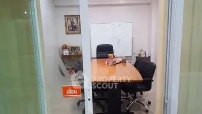 Modern office meeting room with large table and chairs, ideal for business discussions.