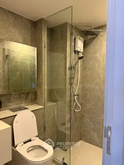 Modern bathroom with glass shower and sleek fixtures in a contemporary apartment.