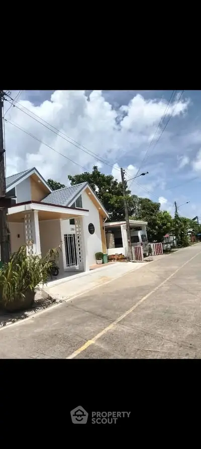 Charming suburban house with modern design and lush greenery on a sunny day.