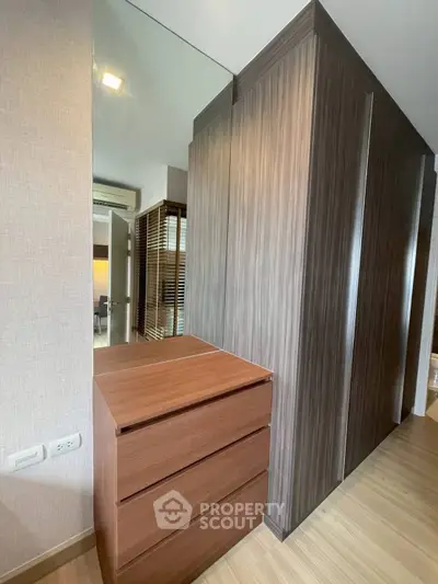 Modern interior with sleek wooden wardrobe and dresser in a stylish apartment.