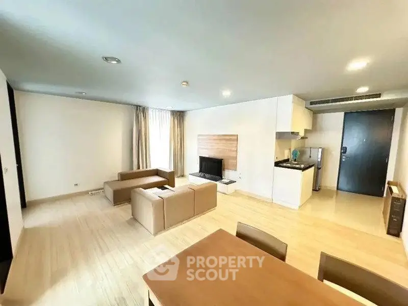 Spacious modern living room with open kitchen and stylish furniture in a contemporary apartment.