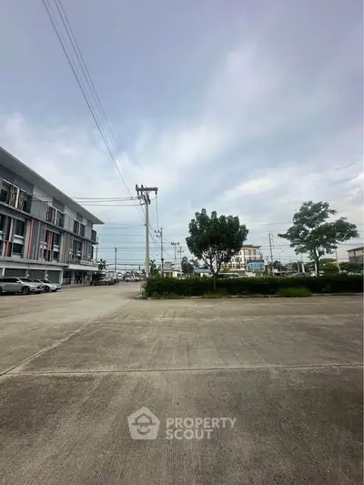 Spacious commercial building exterior with ample parking and clear sky view.