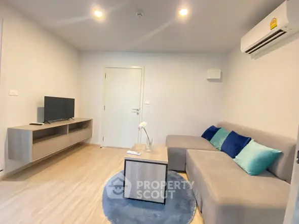 Modern living room with cozy sectional sofa and wall-mounted TV in a stylish apartment.