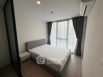 Modern bedroom with large window and minimalist design in a stylish apartment.