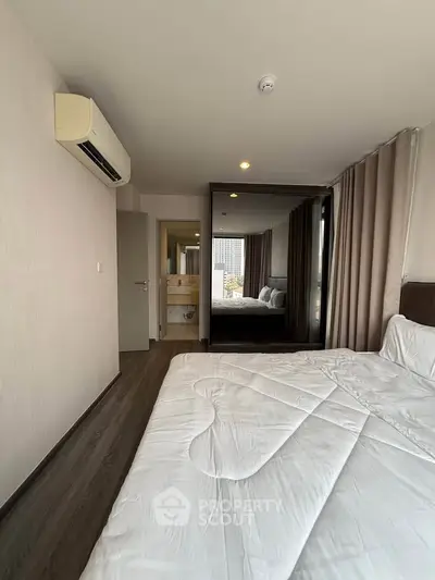 Modern bedroom with air conditioning and mirrored wardrobe in a stylish apartment.