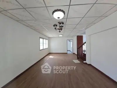 Spacious empty living room with wooden flooring and vintage chandelier