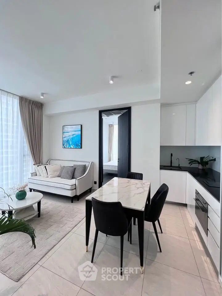 Modern open-plan living room and kitchen with elegant decor and natural light.