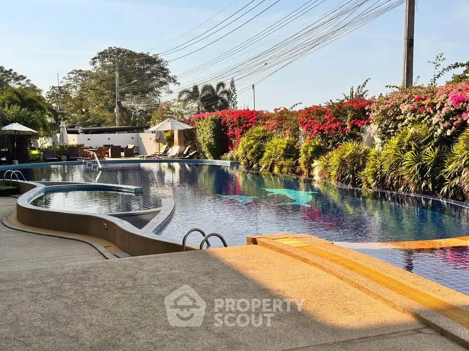 Luxurious outdoor pool area with lush greenery and sun loungers, perfect for relaxation and leisure.