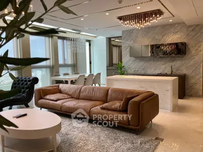 Luxurious open-plan living room with elegant leather sofa and modern kitchen in high-rise apartment.