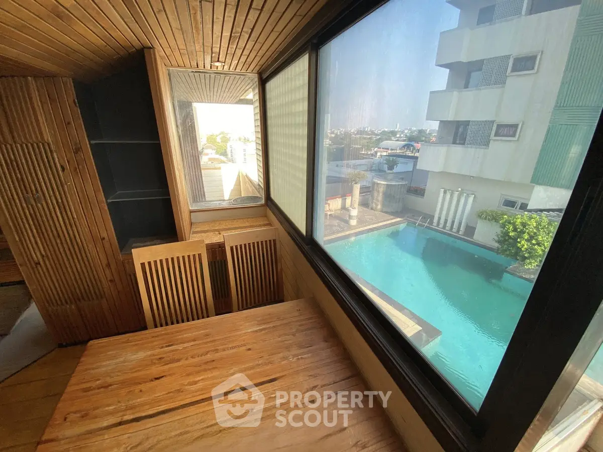 Stunning pool view from modern wooden interior with large windows
