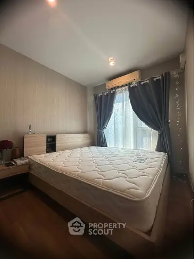 Cozy bedroom with large window and elegant curtains, featuring a comfortable bed and stylish decor.