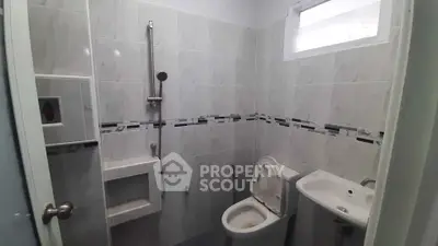 Compact bathroom with modern fixtures and tiled walls