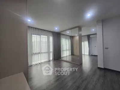 Spacious modern living room with large windows and elegant flooring
