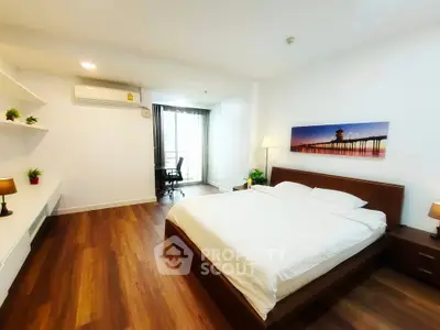 Spacious bedroom with modern decor and large window for natural light