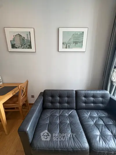 Stylish living room with black leather sofa and elegant wall art, perfect for modern urban living.