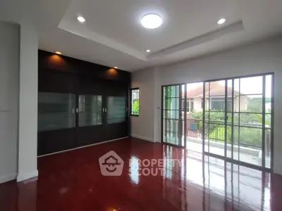 Spacious living room with hardwood floors and large windows overlooking a scenic view.