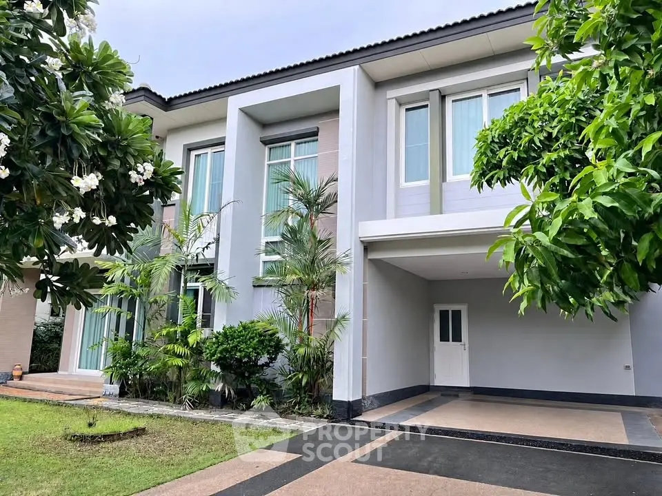 Luxurious modern house exterior with lush garden and spacious driveway
