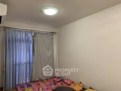 Cozy bedroom with colorful bedding and simple decor, perfect for a child's room.