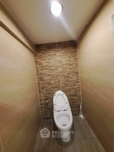 Modern bathroom with sleek tile design and contemporary toilet fixture.