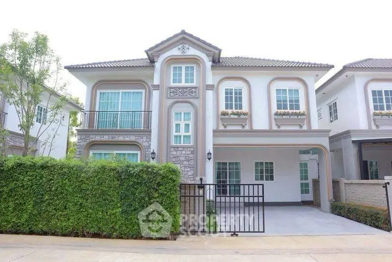 Elegant two-story house with classic design and lush greenery in a serene neighborhood.