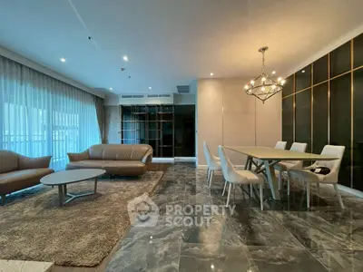 Luxurious open-plan living and dining area with elegant furnishings and modern lighting.