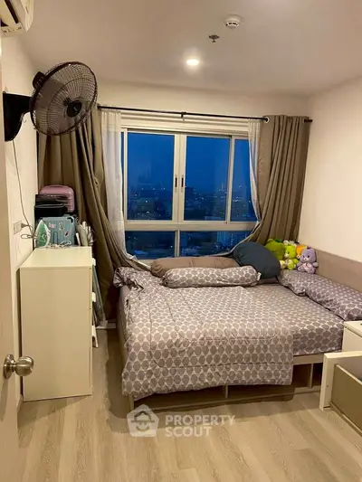 Cozy bedroom with city view, featuring a comfortable bed and stylish decor, perfect for relaxation.