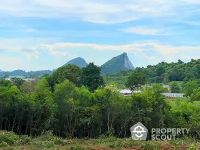 Scenic view of lush greenery and distant mountains, perfect for serene real estate development.