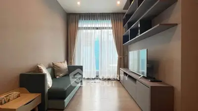 Modern living room with sleek furniture and large window, perfect for relaxation.