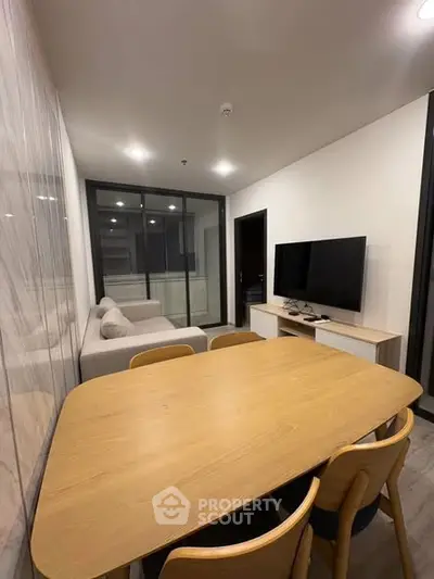 Modern living room with sleek furniture and large TV, perfect for relaxation and entertainment.