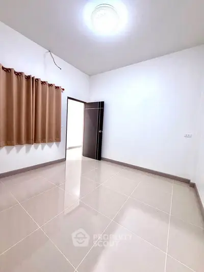 Spacious empty room with glossy tiled floor and brown curtains, ideal for customization.
