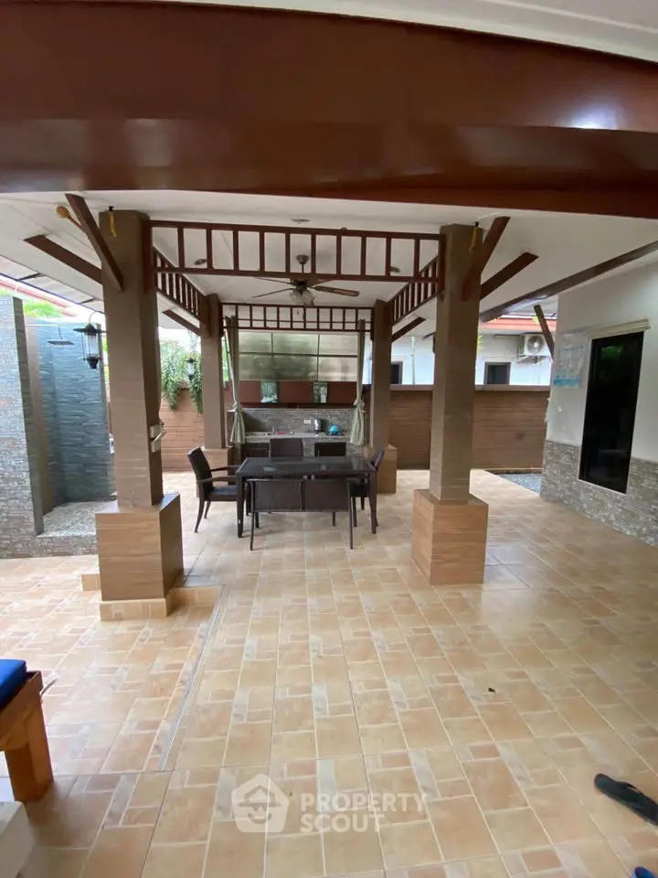 Charming outdoor patio with elegant pergola and dining set, perfect for entertaining guests.