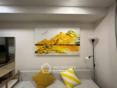 Modern living room with stylish decor and vibrant artwork, featuring cozy seating and elegant lighting.