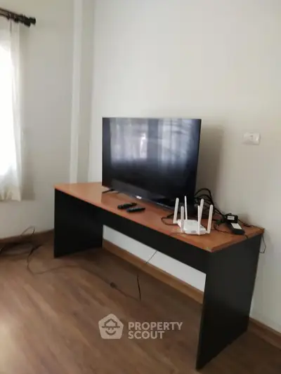 Modern living room with sleek TV setup and wooden flooring