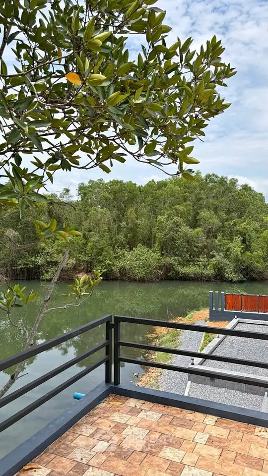 Scenic river view from a modern balcony with lush greenery and serene surroundings.