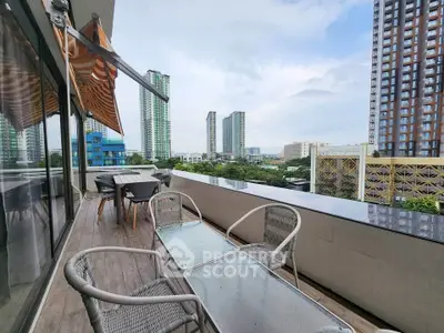 Spacious balcony with city skyline view, perfect for outdoor relaxation and entertainment.