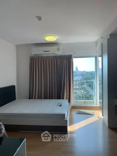 Bright bedroom with balcony view and modern furnishings in a stylish apartment.