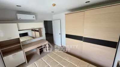 Spacious bedroom with modern furniture and ample storage space