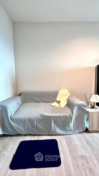 Cozy living room with a modern sofa and minimalist decor, perfect for relaxation.