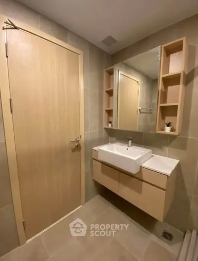 Modern bathroom with sleek vanity and mirror in a stylish apartment.