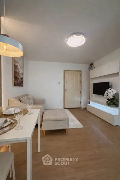 Modern living room with cozy sofa, stylish decor, and elegant dining area in a contemporary apartment.