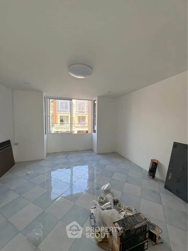 Spacious unfurnished room with large windows and tiled flooring, ideal for customization.