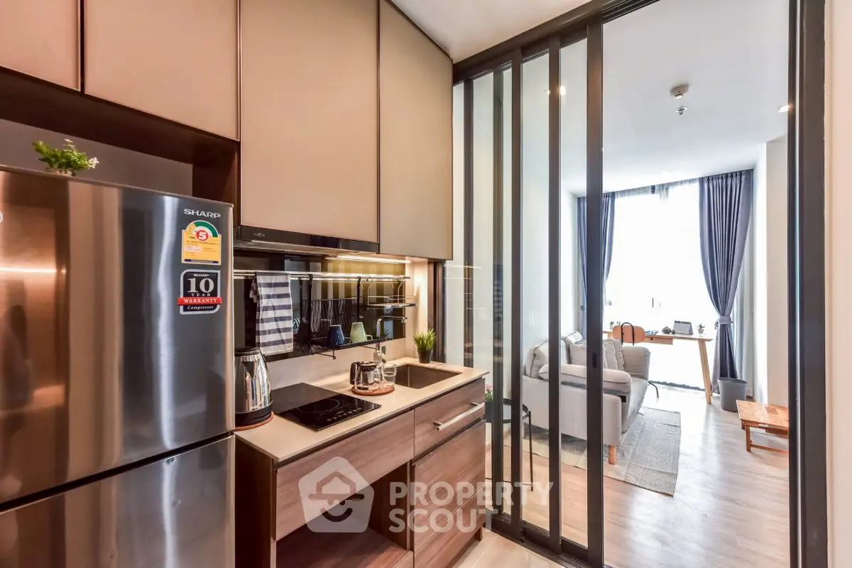 Modern kitchen with sleek appliances and open layout leading to cozy living room